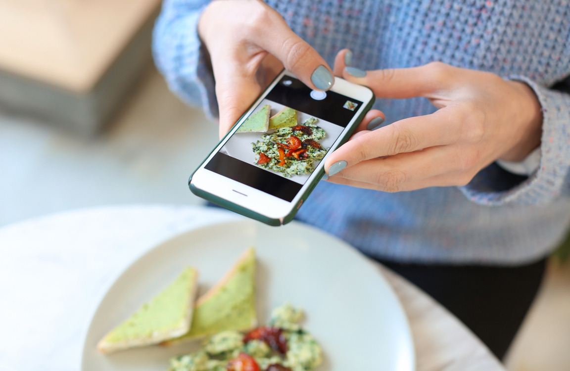 Young Woman Taking Photo Of Her Food  